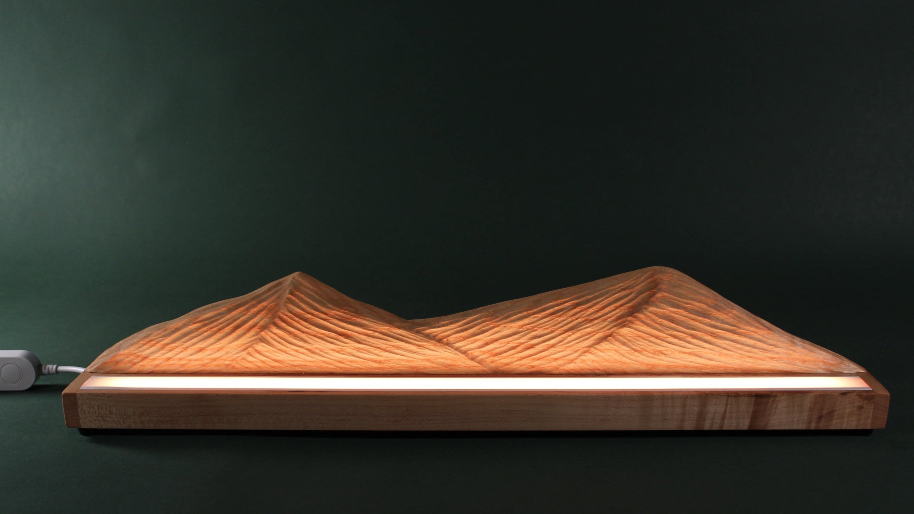 Wooden mountain-shaped lamp on a dark background